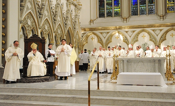 Bishop Richard J. Malone gets a standing ovation from area priests and the faithful after his homily at St. Joseph Cathedral at the Chrism Mass. (Dan Cappellazzo/Staff Photographer)